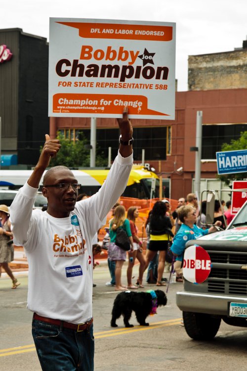 Rep. Bobby Joe Champion marches with his sign at Twin Cities Pride.